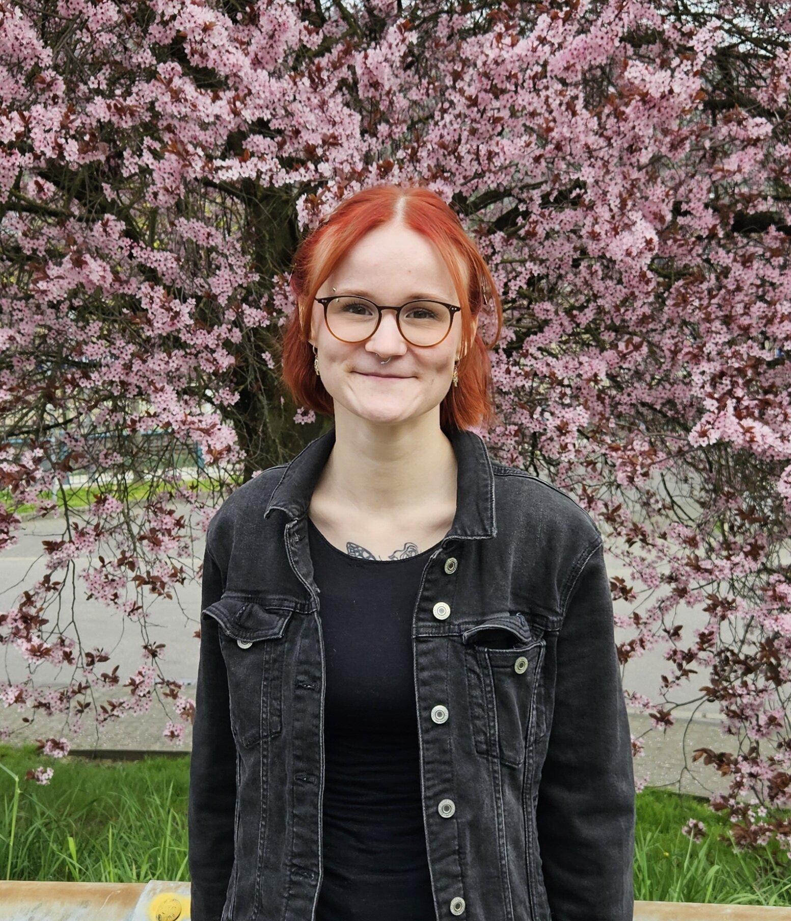 Frau Cara Marie Grözinger vor einem rosablühenden Baum